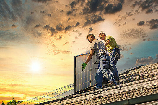 Zwei Männer bauen Solaranlage